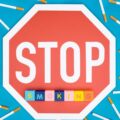 Top view of stop sign, cigarettes and blocks with letters isolated on blue, stop smoking concept